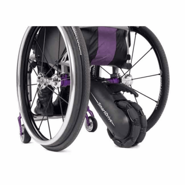Close-up view of a manual wheelchair with a SmartDrive power assist device attached to the rear axle. The wheelchair features black and purple components and is positioned against a plain white background.